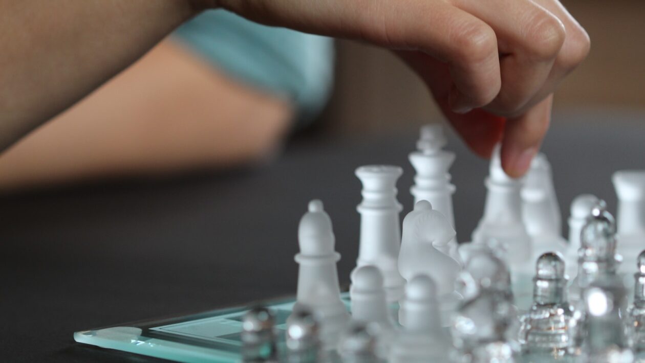 person touching chess piece