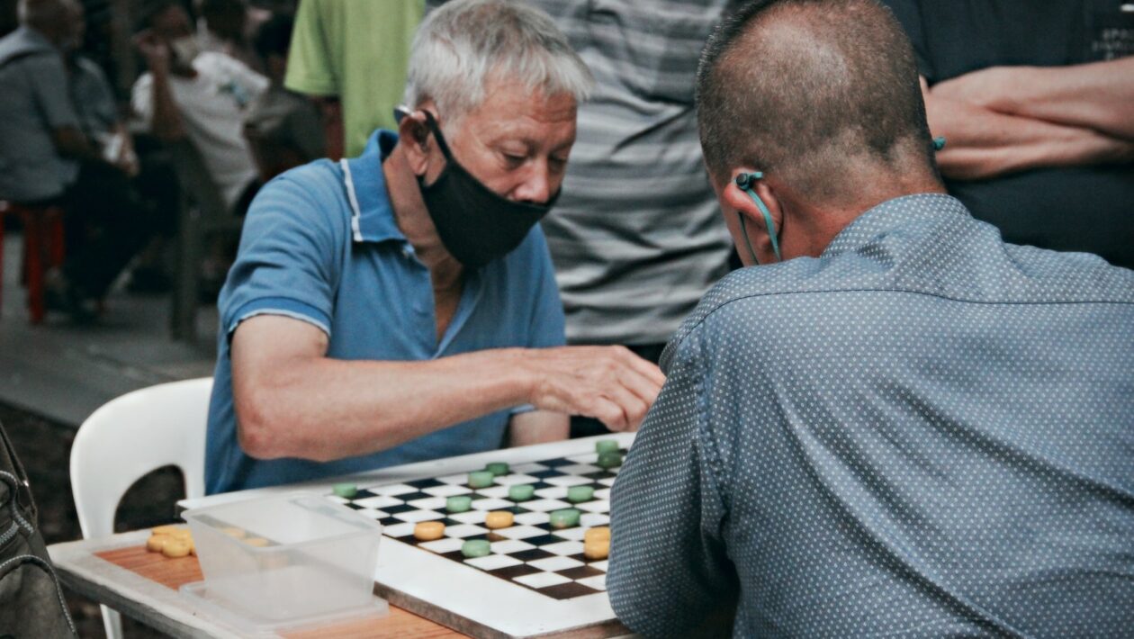 man in blue t-shirt playing chess
