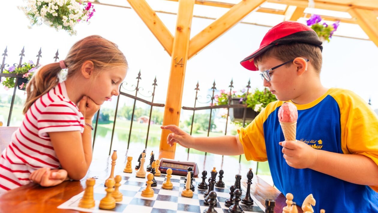 boy in blue t-shirt playing chess