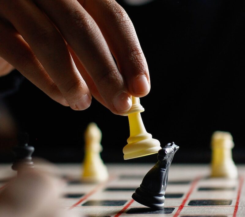 person holding white chess piece
