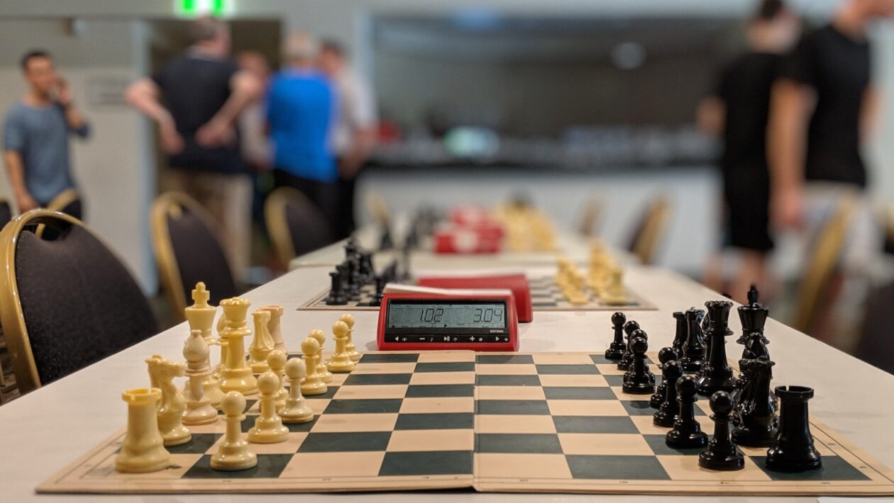 black and white chess board near people standing inside building