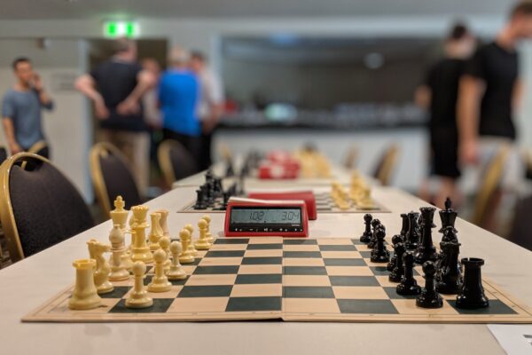 black and white chess board near people standing inside building
