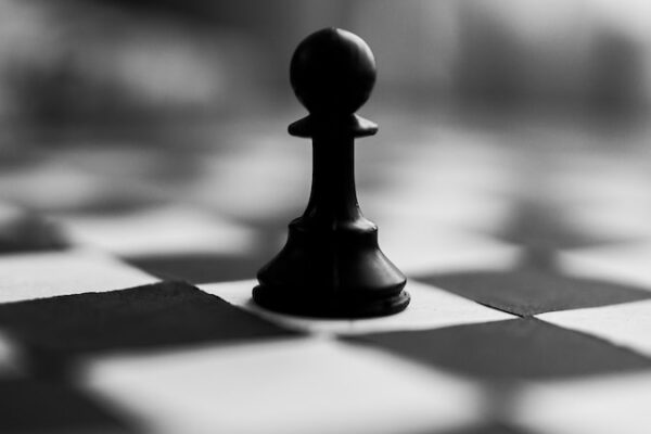 black chess piece on white and black checkered textile