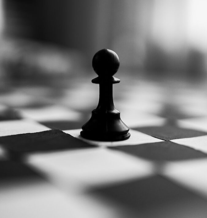 black chess piece on white and black checkered textile