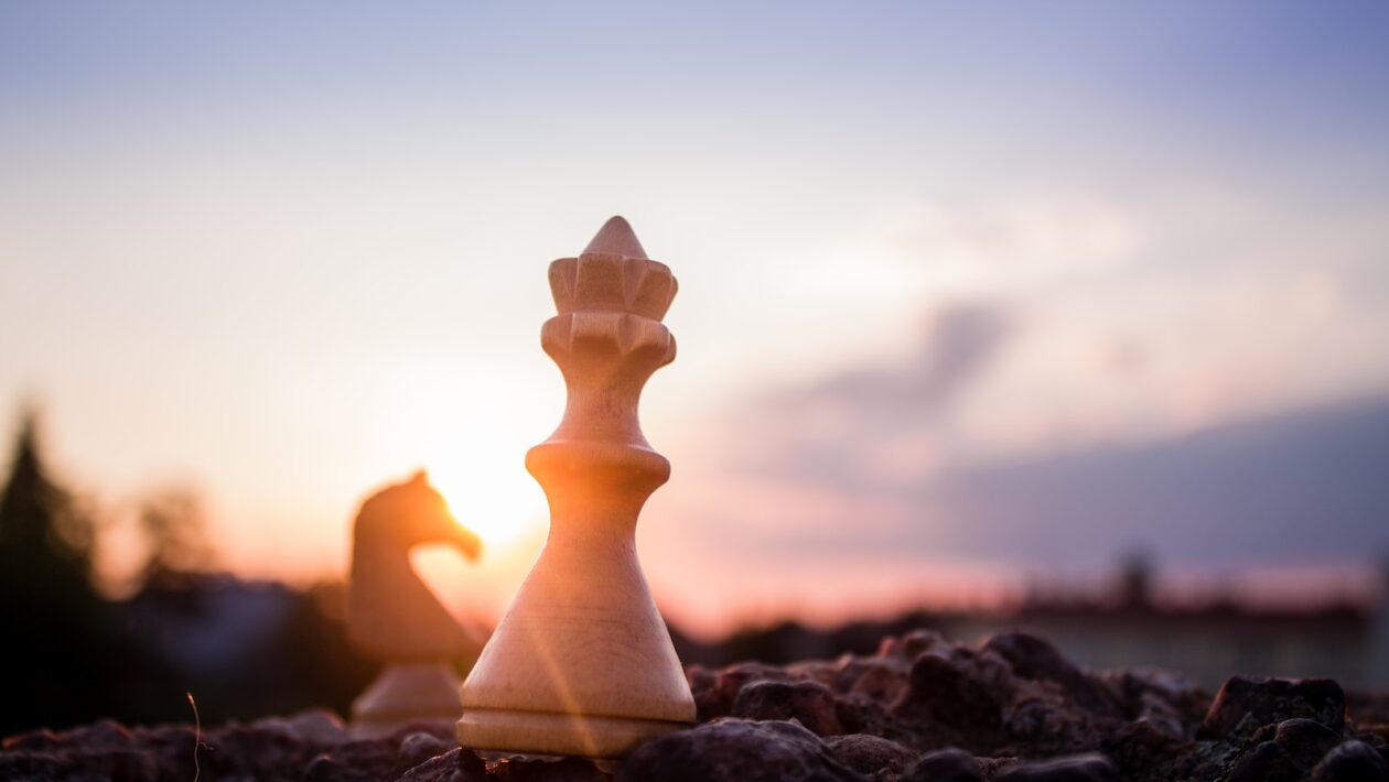 bishop chess piece on black rock at daytime