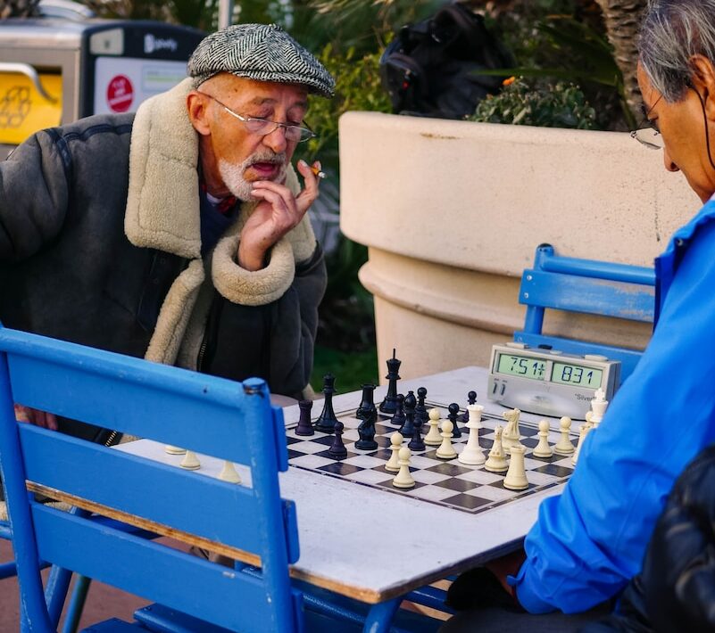 man in blue jacket sitting on blue chair